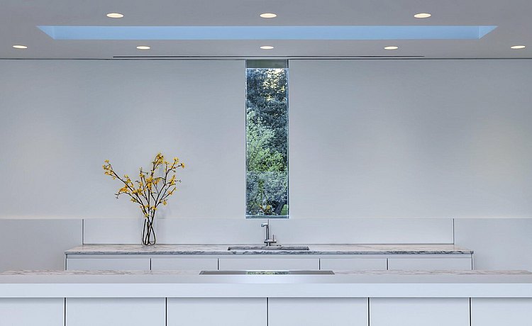 Kitchen in alpine white laminate and window with view of trees
