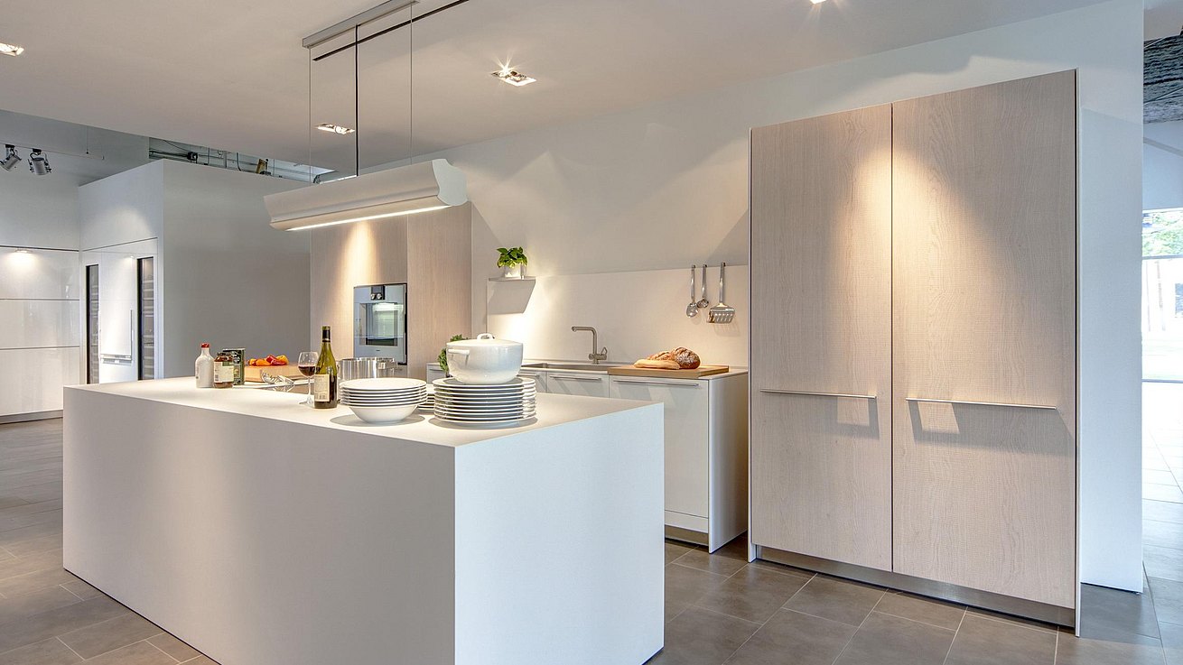 b3 kitchen in white laminate and oak with dishes and meal preparation ingredients set out on the island.