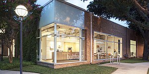 View of exterior of bulthaup Dallas showroom at dusk with b3 display kitchen glowing warm and welcoming.